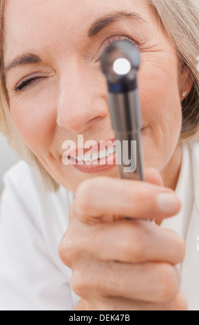 Nahaufnahme von senior weiblichen medizinischen Klinik Ärztin mit einem Otoskop oder Ohr Spekulum, einen Patienten zu untersuchen Stockfoto
