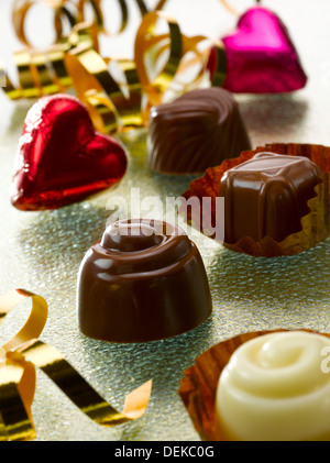 Pralinen mit kunstvollen Verpackungen und Band, studio Stockfoto