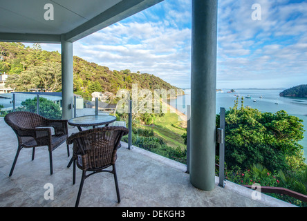 Tisch und Stühle auf dem Balkon mit Blick auf die Bay of Islands, Paihia, Neuseeland Stockfoto