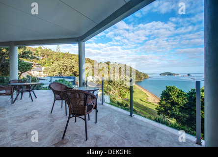 Tisch und Stühle auf dem Balkon mit Blick auf die Bay of Islands, Paihia, Neuseeland Stockfoto