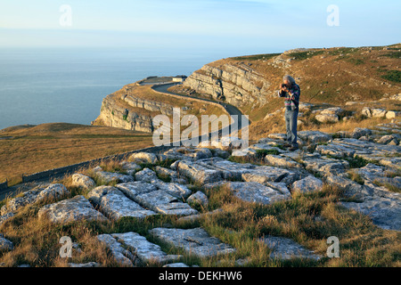 Kalkstein-Landschaft: eine Kalkstein-Pflaster auf den Great Orme Landzunge, Llandudno, Nordwales. Kalkstein-Klippen im Hintergrund. Stockfoto