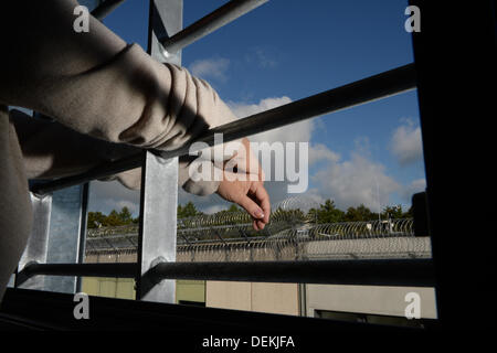 Ravensburg, Deutschland. 19. September 2013. Ein weiblicher Häftling stellt bei einem vergitterten Fenster im Neubau des Gefängnisses in Ravensburg, Deutschland, 19. September 2013. Foto: Felix Kaestle/Dpa/Alamy Live News Stockfoto