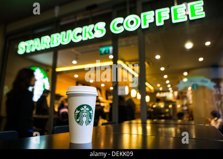 Ein Starbucks Kaffee Tasse auf einem Tisch außerhalb Starbucks Coffee-Shop, Canary Wharf. London, UK. Stockfoto