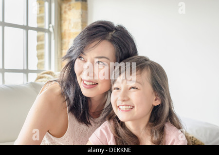 Mutter und Tochter lächelnd auf sofa Stockfoto