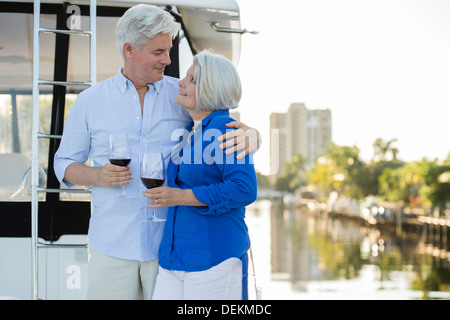 Älteres kaukasischen Ehepaar mit Wein auf Bootsdeck Stockfoto