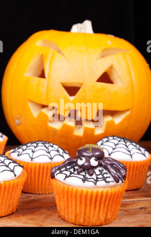 Cupcakes und Kürbis auf Holztisch. Stockfoto