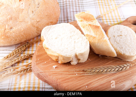 geschnittenem Brot auf das Holzbrett und Weizen Stockfoto