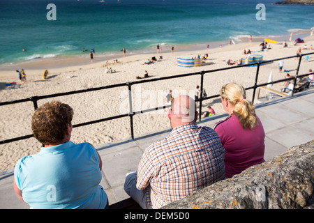 Übergewichtige Menschen infront von Porthmeor Beach in St. Ives, Cornwall, UK. Stockfoto