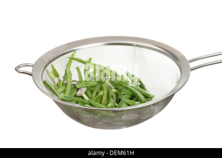 Grüne Stangenbohnen in ein Edelstahlsieb isoliert gegen weiß Stockfoto