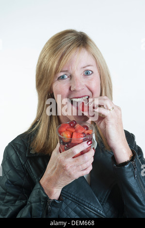 Essen frisches Obst, Salat aus Plastikbecher mit einem Plastiklöffel Frau Stockfoto