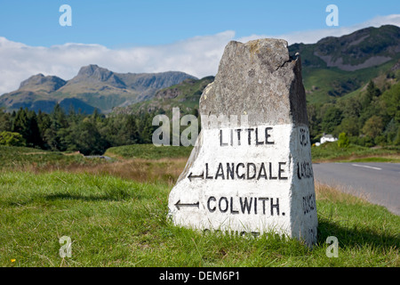 Nahaufnahme eines Meilensteins der Steinstraße in der Nähe von Elterwater mit Langdale Pikes im Hintergrund im Sommer Cumbria England Vereinigtes Königreich Großbritannien Stockfoto