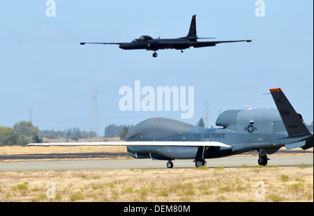 Eine RQ-4 Global Hawk Unmanned Aerial Vehicle rollt auf der Flightline, wie ein u-2-Spionageflugzeug Endanflug landen macht 17. September 2013 auf der Beale Air Force Base, Kalifornien. Die RQ-4 und u-2 sind die Air Force primäre Hochgebirgs Intelligenz, Überwachung und Aufklärung Flugzeuge. Stockfoto