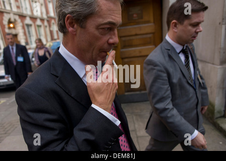 UKIP (UK Independence Party) führend, was Nigel Farage raucht nach Angabe TV interviews während seiner schwierigen und umstrittenen ersten Tag der Konferenz seiner Partei in Westminster, Zentrum von London. Stockfoto