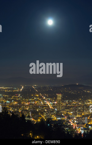 Ernte Vollmond Aufstieg in Portland Oregon am Abend mit Lichter der Stadt und Traffic Light Trails in der Nacht Stockfoto