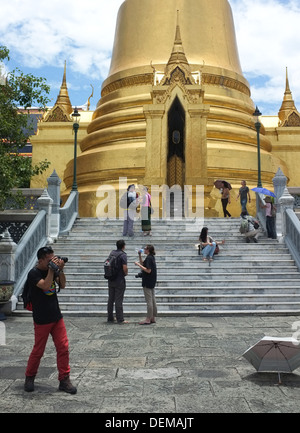 Touristen fotografieren an der goldenen Phra Si Rattana Chedi im Grand Palace in Bangkok Komplex Stockfoto