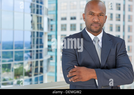 Erfolgreicher afroamerikanischer Geschäftsmann oder Mann in einem Anzug in einer modernen Stadt Stockfoto