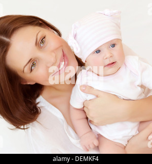 Closeup Portrait schöne junge Mutter tragen kleine Baby zu Hause, gesunde Kindheit, des Kindes Sicherheitskonzept Stockfoto