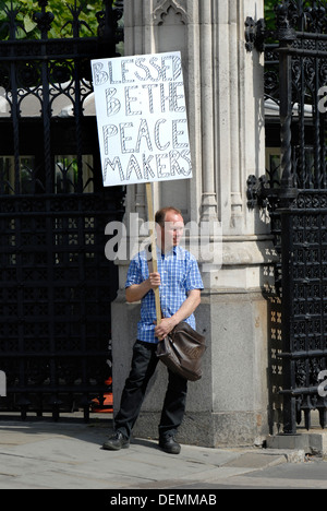 London, England, Vereinigtes Königreich. Einsame Kämpferin außerhalb des Parlaments mit religiösen Plakat Aufruf für Frieden (in Syrien, 2013) Stockfoto