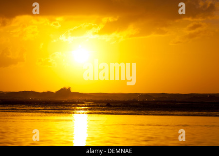 Sonnenuntergang mit hohen Wellen hinter dem Riff und ruhigem Wasser vorne am Ke'e Beach in Kauai, Hawaii. Stockfoto