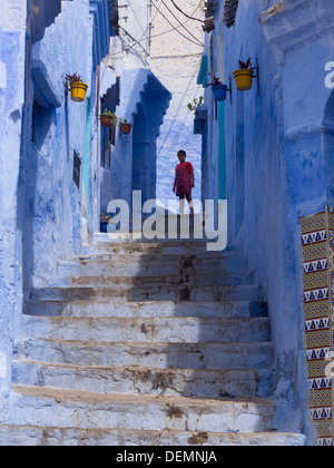 Junges Mädchen in einer Straße mit blau gestrichenen Häuser in Chefchaouen, Marokko Stockfoto