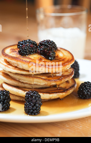 wunderschöne und leckere amerikanische Pfannkuchen mit Ahornsirup und Brombeeren Stockfoto