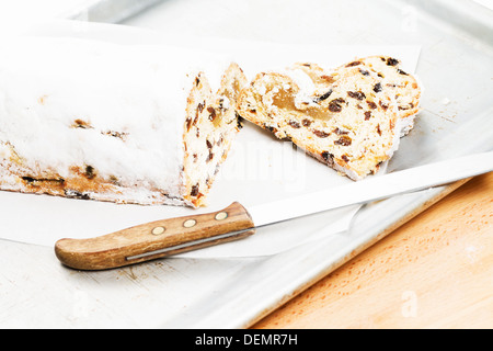 Christstollen Kuchen mit einem Messer auf einem silbernen Metall Backblech Stockfoto