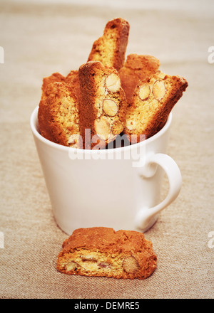 Cantuccini Kekse in eine Kaffeetasse auf Leinenstoff Stockfoto