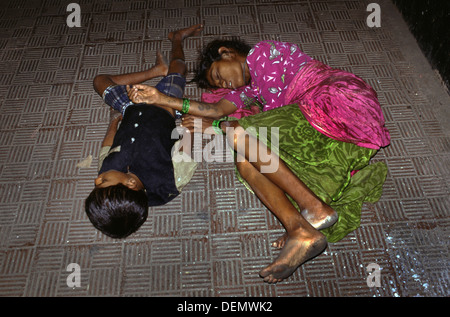 Eine obdachlose Frau schlafen mit ihrem Sohn auf dem Bürgersteig in Mumbai, Indien Stockfoto