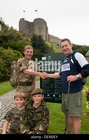 Criccieth Schloß, Gwynedd, Wales. 21. September 2013. Gardist Caleb Allport (links) und Steve Chapel (rechts) eine Pause am Criccieth Schloß, Gwynedd, mit Caleb es Brüder Max und Finlay (sitzend), während der 5. Etappe der "Walk in Wales" Charity walk Ansatz. Die 870 Meile zu Fuß wird im Gedenken an den 50 Welsh Guards im aktiven Dienst seit dem 2. Weltkrieg getöteten durchgeführt. Dieses Tages-Wanderung, gesponsert von Steve Chapel Unternehmen, Markt Fit Gruppe widmet sich Lance Corporal A Burke auf RFA Sir Galahad am 8. Juni 1982, im Alter von 23. Stockfoto