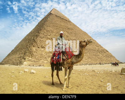 Ein Kamel Mann auf seinem Kamel posiert vor Pyramide des Chephren, die zweitgrößte der erstaunlichen Pyramiden von Gizeh. Stockfoto