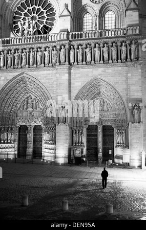 Mann steht außerhalb Kathedrale Notre Dame de Paris (Muttergottes) in der Nacht. Stockfoto