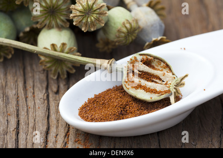 Mohn in eine weiße Porzellanschale mit Blüten auf einem alten Holztisch Stockfoto