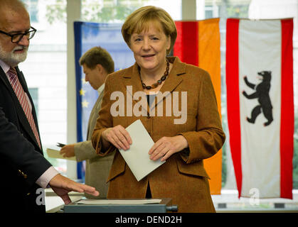 Berlin, Deutschland. 22. September 2013. Bundeskanzlerin Angela Merkel steht mit ihrem Stimmzettel in einem Wahllokal in Berlin, Deutschland, 22. September 2013. Foto: MICHAEL KAPPELER/Dpa/Alamy Live News Stockfoto