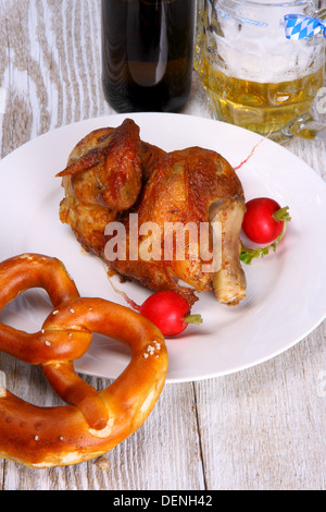 Oktoberfest-Huhn mit Brezel, Radieschen und Bier, Nahaufnahme Stockfoto