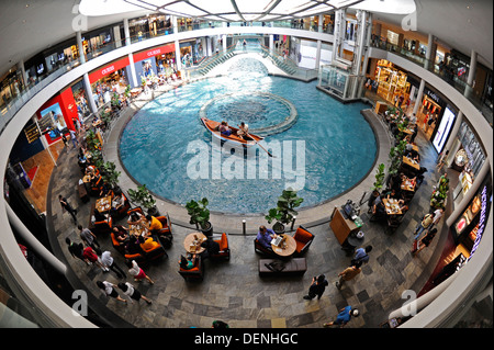 Shopper mit einem Boot fahren Sie in einer Gondel auf die Shoppes at Marina Bay Sands Einkaufszentrum in Singapur. Stockfoto