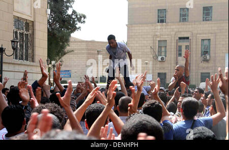 Kairo, Ägypten. 22. September 2013. Ägyptische Studenten der Universität Kairo offene Handflächen mit vier erhobenen Finger, gewordene Symbol der Rabaah al-Adawiya Moschee, wo Mursi-Anhänger ein Sit-in wochenlang gehalten hatte, die heftig im August, während einer Protestaktion am ersten Tag des neuen akademischen Jahres, bei der Unterstützung des Ägyptens gestürzten islamistischen Präsidenten Mohamed Morsi, in Kairo am 22. September verteilt wurde , 2013 Credit: Ahmed Asad/APA Images/ZUMAPRESS.com/Alamy Live-Nachrichten Stockfoto