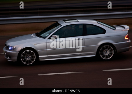 Hinten Sync Flash-Technik verwendet, um ein BMW-Auto reisen entlang der Schnellstraße von Dundee in den späten Abend, UK erfassen Stockfoto