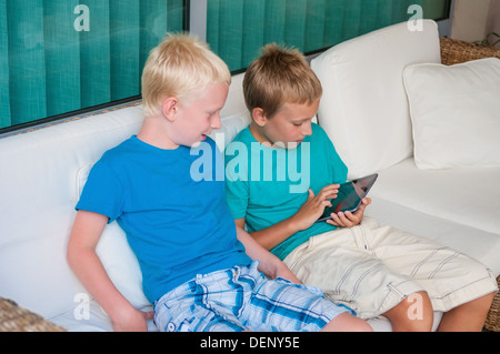 Zwei Brüder, die auf dem Touchscreen Tablet PC spielen Stockfoto