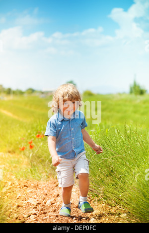 Kleine Junge im grünen Feld laufen auf sonnigen Tag Stockfoto