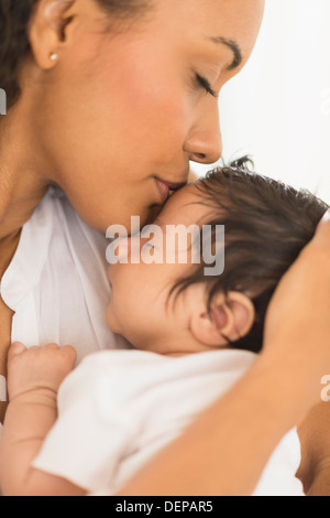 Hispanische Mutter küssen Säuglingssohn Stockfoto