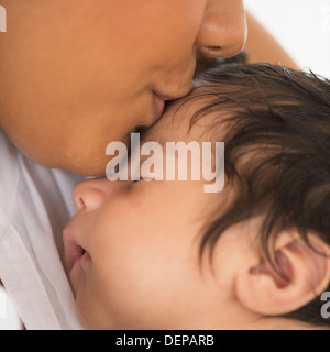 Hispanische Mutter küssen Säuglingssohn Stockfoto