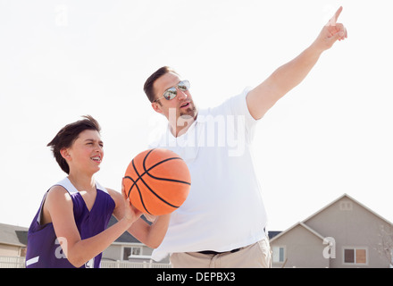 Vater Lehre Sohn spielen Basketball in Einfahrt Stockfoto