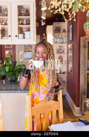 Afroamerikanische Frau, die Tasse Kaffee in der Küche Stockfoto