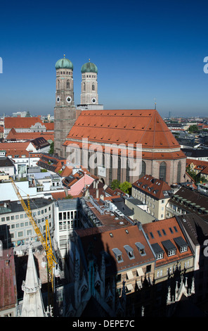 einen atemberaubenden Blick auf die Frauenkirche in München Innenstadt über die Dächer vom Turm der St. Peterskirche an einem heißen sonnigen Tag Stockfoto