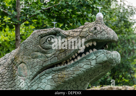 Weingläser links auf eine der vielen Dinosaurier-Skulpturen im Bereich "Dinosaurier" von Crystal Palace Park, London, England. Stockfoto