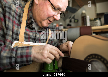 Gitarrenbauer Veredelung Akustikgitarre in Werkstatt Stockfoto