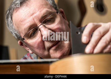 Nahaufnahme von Gitarrenbauer Veredelung Akustikgitarre in Werkstatt Stockfoto