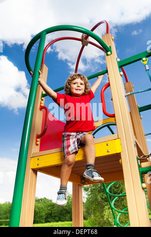 Glücklich drei Jahre alten Jungen Geißlein sitzen auf Spielplatz bereit zu schieben Stockfoto