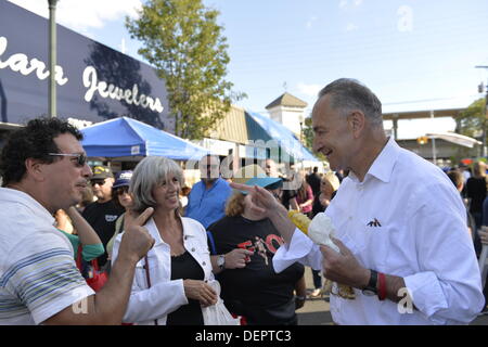 Bellmore, New York, USA 22. September 2013. US-Senator CHARLES "CHUCK" SCHUMER (Demokrat), für eine Wiederwahl im November laufen macht eine Kampagne am 27. jährlichen Bellmore Festival besuchen mit Familienspaß mit Ausstellungen und Attraktionen in einem Bereich von 25 quadratischer Block, mit mehr als 120.000 Menschen voraussichtlich über das Wochenende teilnehmen. Senator Schumer und Mann mit einem Lächeln sie zueinander zeigen und sprechen. Bildnachweis: Ann E Parry/Alamy Live-Nachrichten Stockfoto