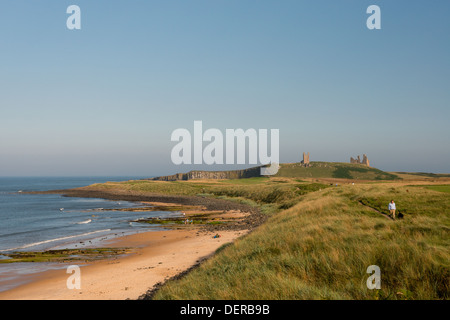 Wanderer auf dem Rasen bedeckt Dünen in der Nähe der Ruinen von Dunstaburgh Burg, Embleton, UK Stockfoto